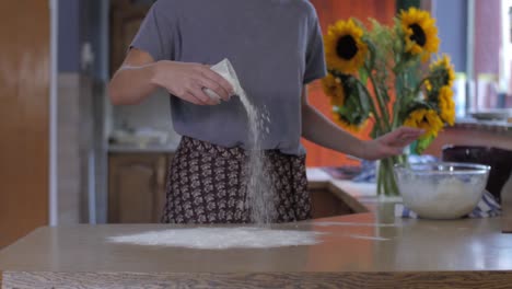 woman flouring a surface in a kitchen