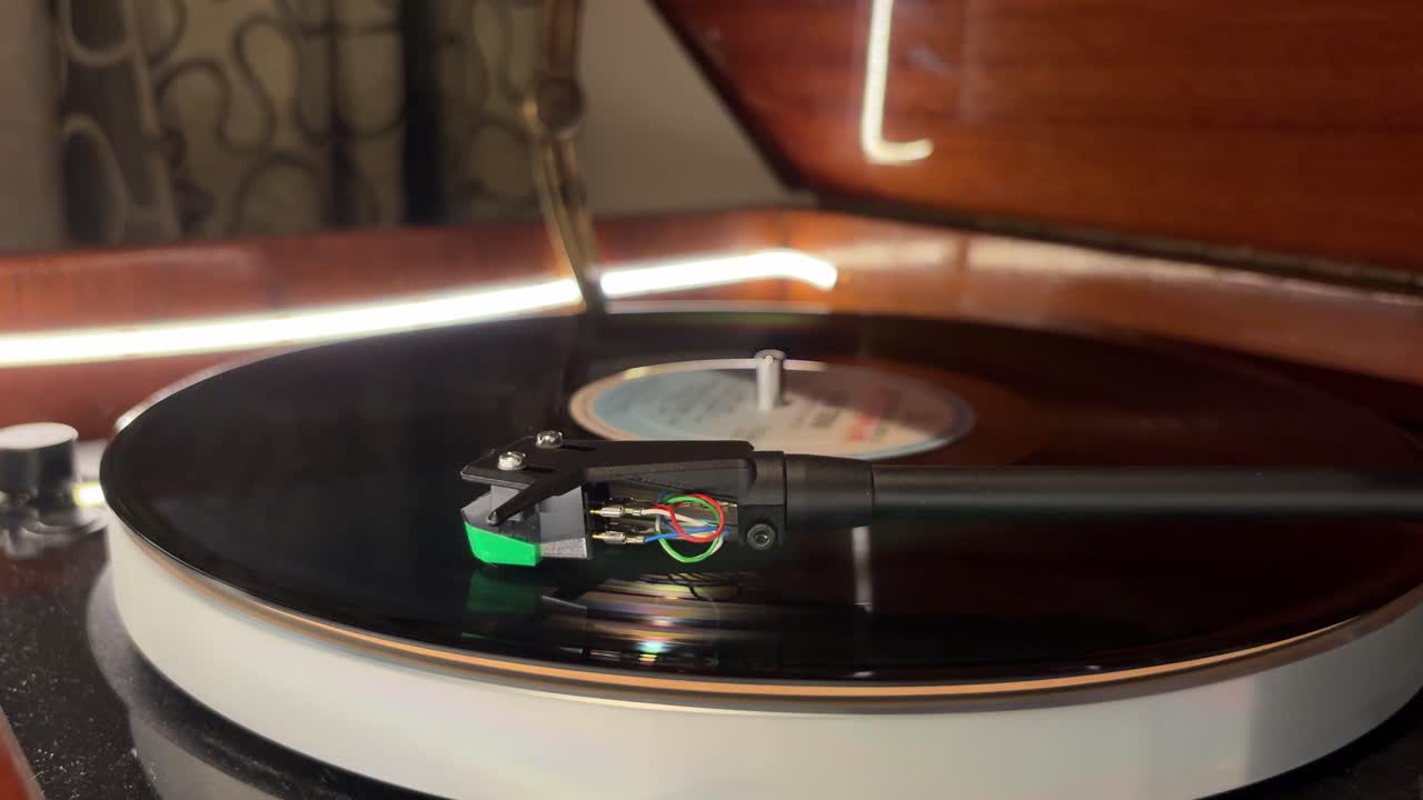 Modern record player spinning on a sleek piece of furniture. Static close up