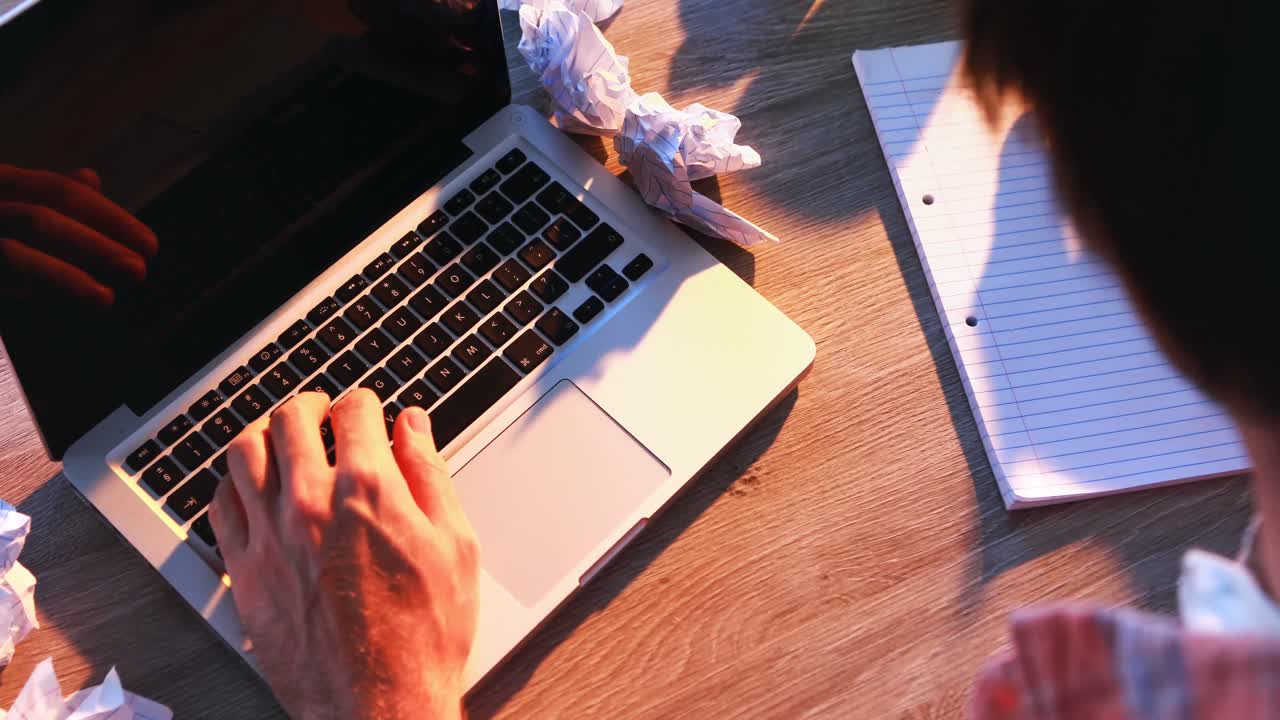 ejecutivo masculino escribiendo en papel mientras usa una computadora portátil en su escritorio 4k