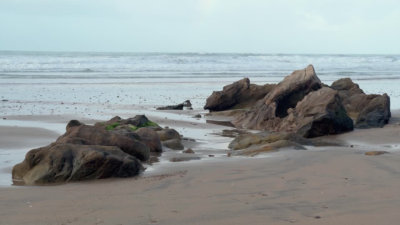 la escarpada y rocosa costa de españa está bordeada por las olas del océano que se estrellan en la distancia, capturando una tranquila vista diurna de esplendor natural.