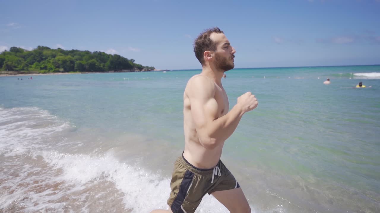 아침에 해변에서 달리기. 느린 동작.