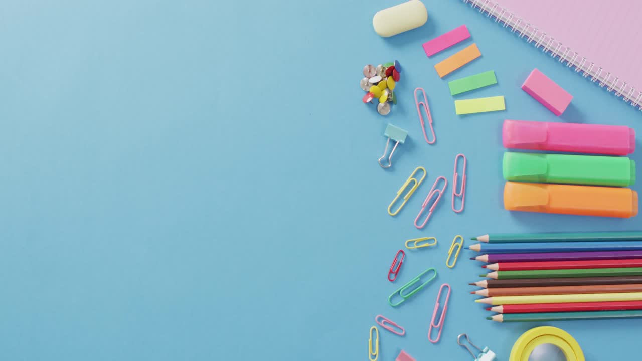 파란색 배경에 다양한 사무실 용품, 펜, 종이 클립, 핀의 비디오