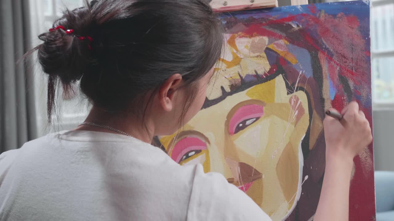 Back View Of An Asian Artist Girl In Wheelchair Holding Paintbrush Mixed Colour Thinking And Painting A Girl On The Canvas