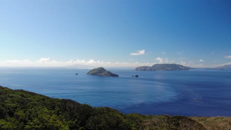 Forwards-aerial-drone-flight-over-island-towards-beautiful-islands-in-blue-ocean