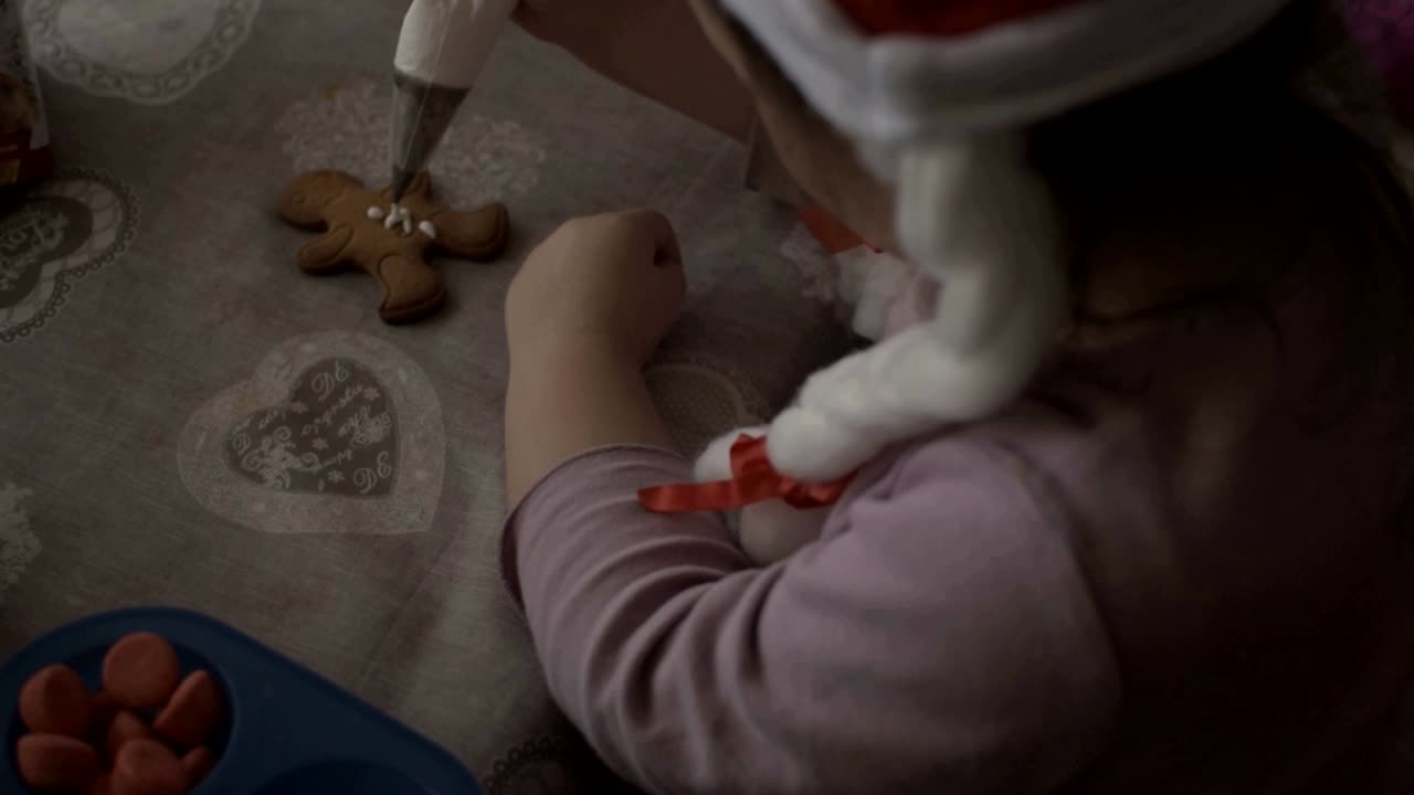 일부 크리스마스 진저 쿠키를 장식으로 장식하는 아기 소녀