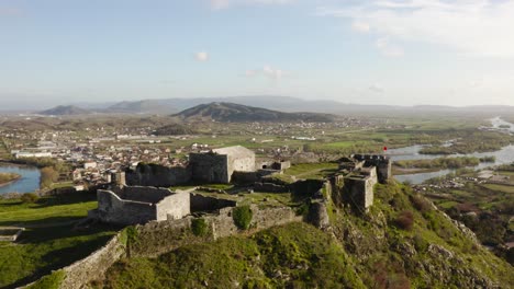 ruins and walls of ancient shkoder castle at hilltop above river valley in albania at sunny day