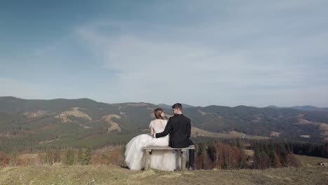 newlyweds. caucasian groom with bride on mountain slope. wedding couple. happy