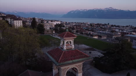 Slow-aerial-orbit-shot-of-a-Swiss-casino-in-Lausanne-with-Lake-Geneva-in-the-background-at-sunset