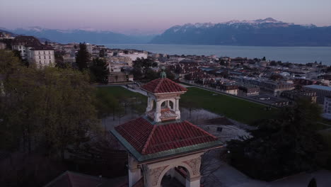 slow aerial orbit shot of a swiss casino in lausanne with lake geneva in the background at sunset