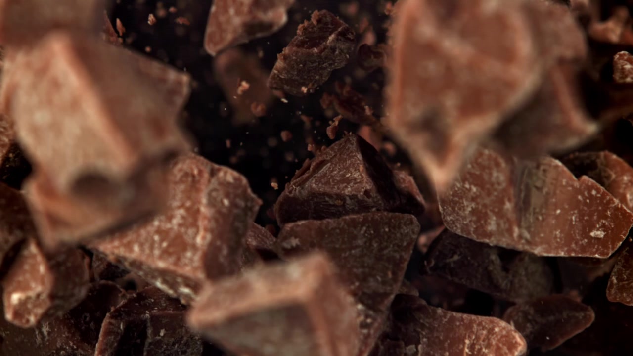 Deliziosi pezzi di cioccolato che cadono al rallentatore