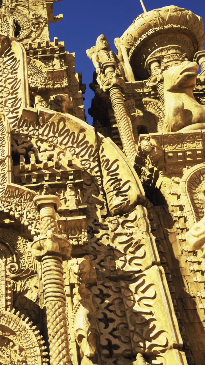 Ornate carvings on historic building under clear blue sky in city