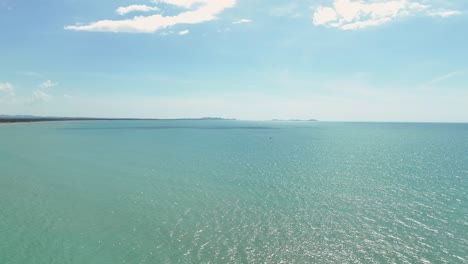 vista aérea ascendente del océano abierto y el agua de mar vacía en un día de cielo azul claro