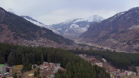 revelando la montaña a través de los árboles de un dron disparado en las montañas nevadas de himachal pradesh en india-2