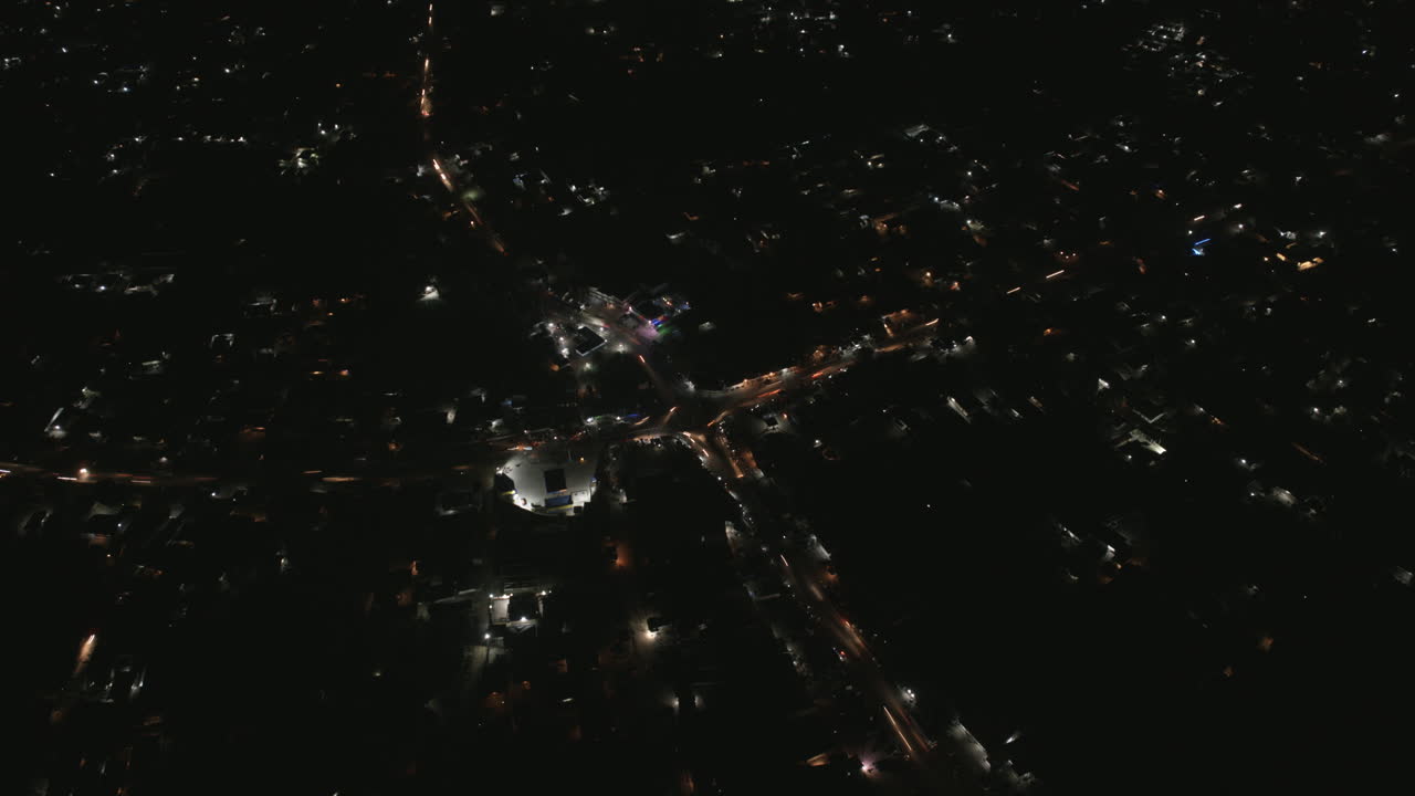Wide aerial hyperlapse of busy intersection in Bo, Sierra Leone at night.