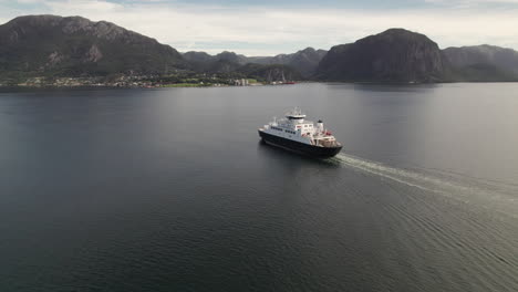 impressive rotating drone shot of a car ferry crossing a beautiful fjord in norway, lauvvika-oanes, near stavanger, summer sunny day