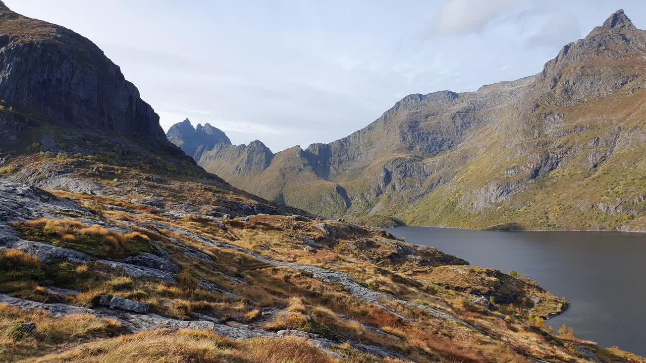 Langsamer Blick über einen See vor steilen, schroffen Bergen auf den Lofoten in Norwegen.