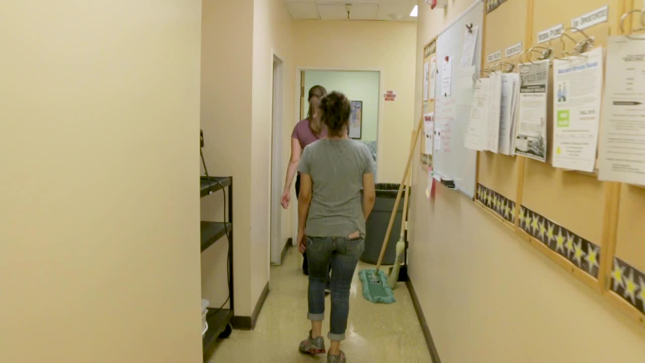 Due donne che camminano lungo un corridoio in una scuola elementare