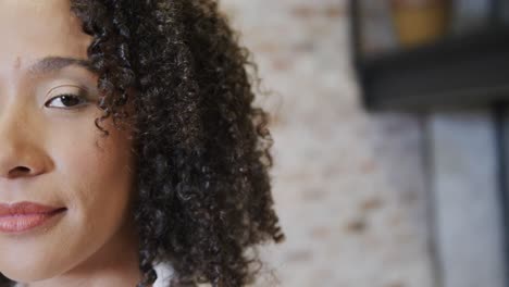 Half-portrait-of-happy-biracial-businesswoman-looking-at-camera-and-smiling,-copy-space,-slow-motion