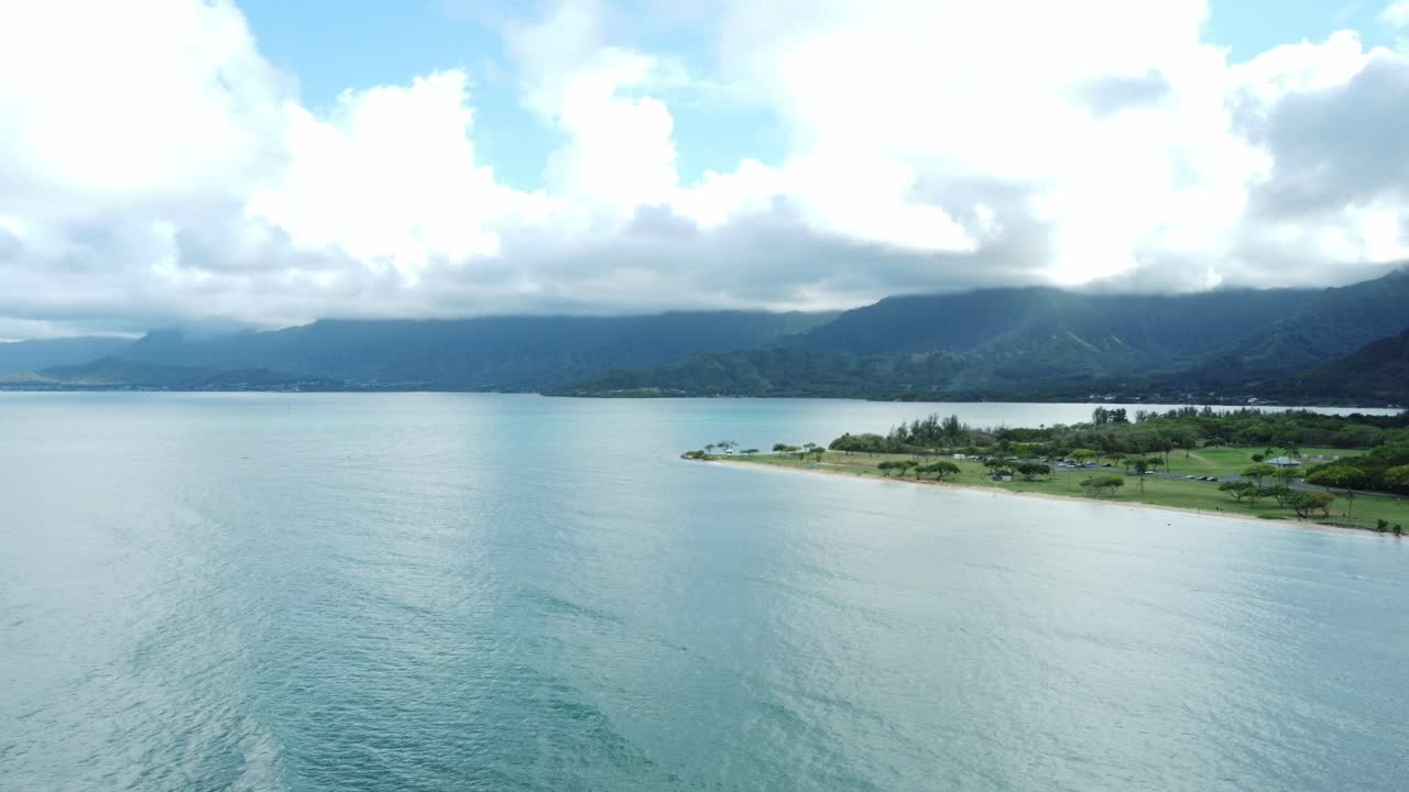 드론으로 촬영된 공중 영상은 하와이 오아후 근처의 순수한 바다를 보여줍니다. 빛이 평온한 물에서 반사되어 열대 해안선을 따라 조용하고 그림 같은 장면을 만니다.