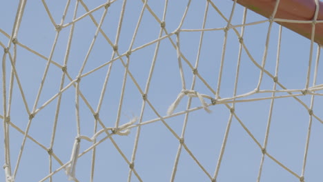 a broken net hung on a football goal