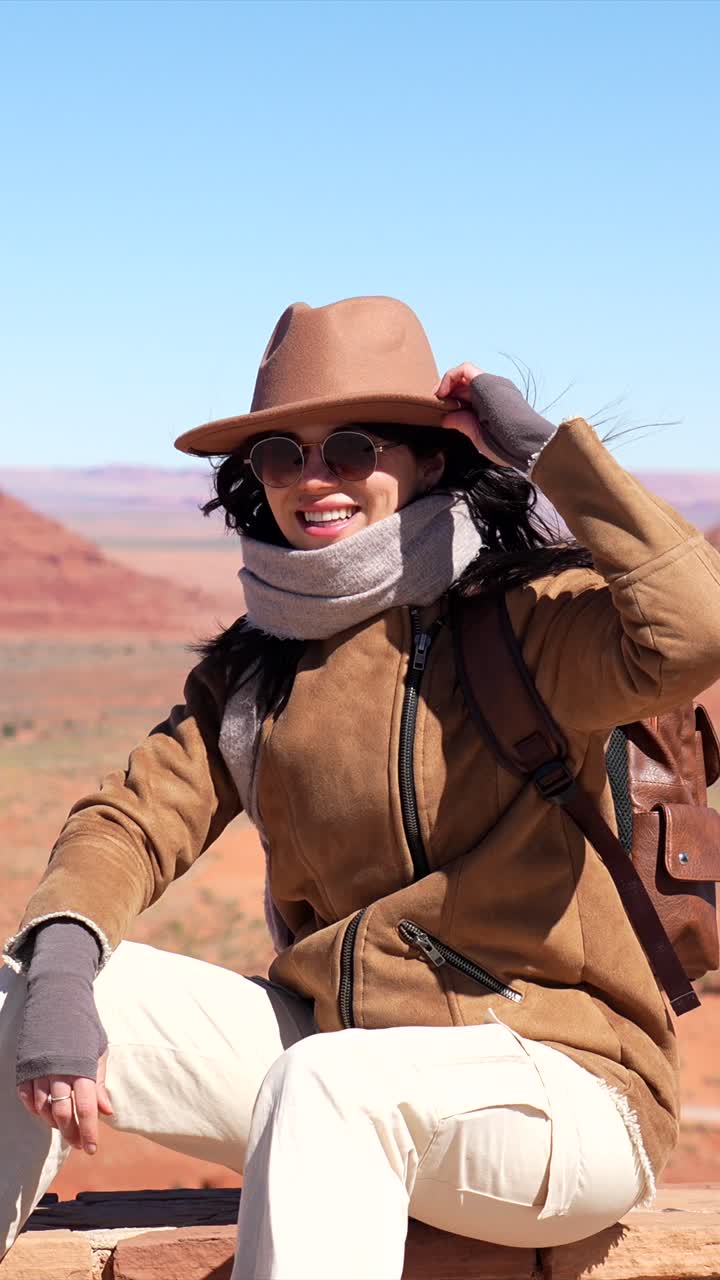 Donna viaggiatrice felice che sorride nel paesaggio desertico della Monument Valley