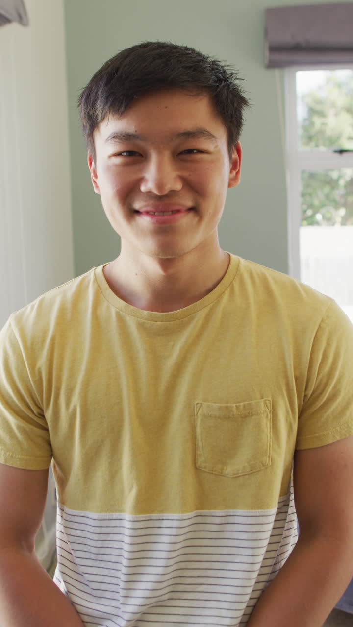 거실에서 행복한 아시아 남자의 초상화의 수직 비디오