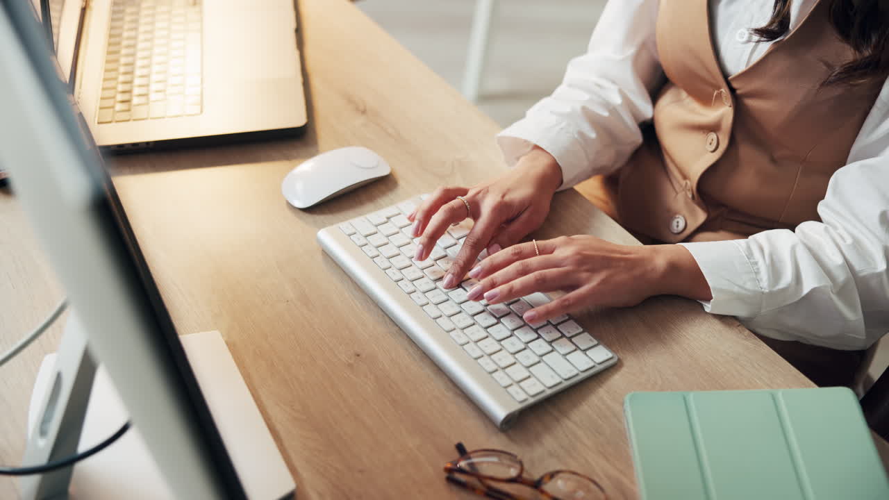 Woman typing on a keyboard at her desk