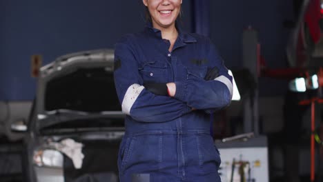 Retrato-De-Una-Mecánica-Femenina-Con-Los-Brazos-Cruzados-Sonriendo-En-Una-Estación-De-Servicio-De-Automóviles