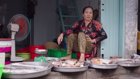 woman selling fish at a market stall