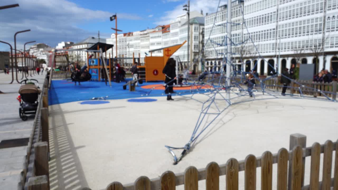 Uskarpt. Børn på legepladsen ved byens promenade. Børn på legepladsen ved byens promenade. La Coruna, den store by i det nordvestlige Spanien, feriestedet og havnen.