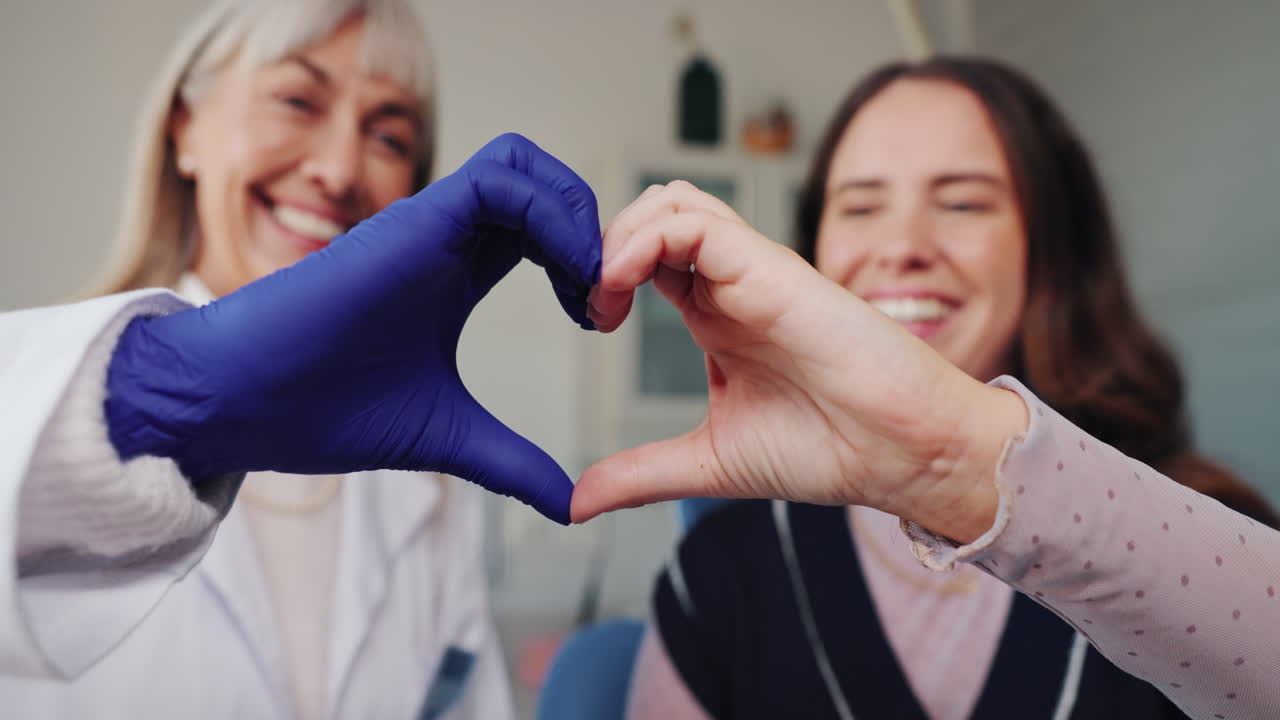 Dentist and patient making heart shape with hands