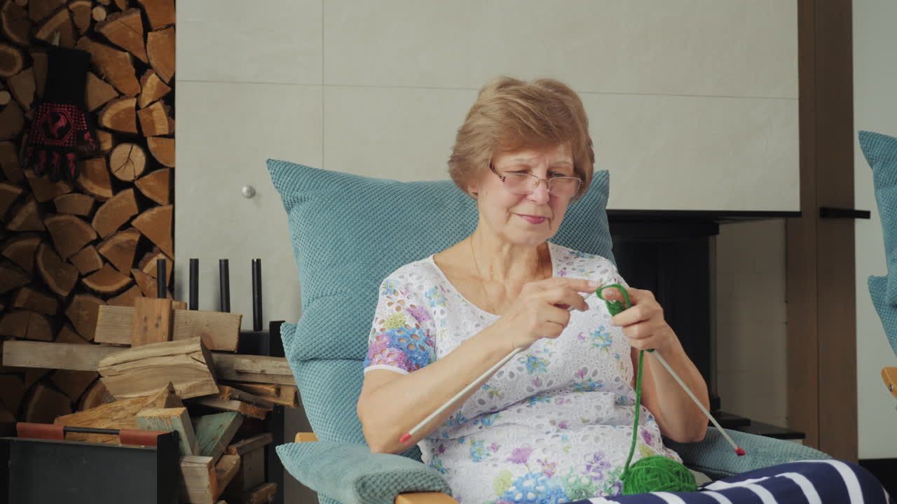 쾌적 한 거실 에서 뜨개질 하는 고위 여성