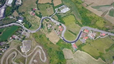 bird's eye view of vast landscape in italy near san marino with river revealed in distance. aerial tilt-up
