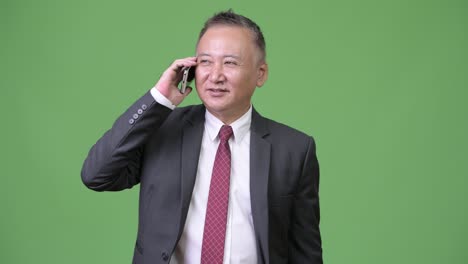 mature japanese businessman using phone