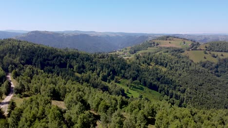 aerial-view-over-Marisel-village-and-Apuseni-Mountains-in-Cluj,-Romania