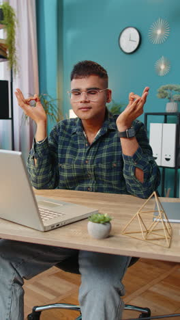 Indian-man-working-on-laptop-eyes-closed-meditating-concentrated-thoughts-taking-a-break-relaxing