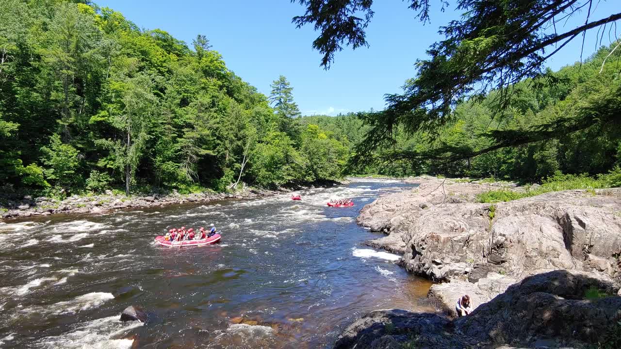 grupos de personas haciendo rafting en tres grandes balsas en un hermoso día soleado