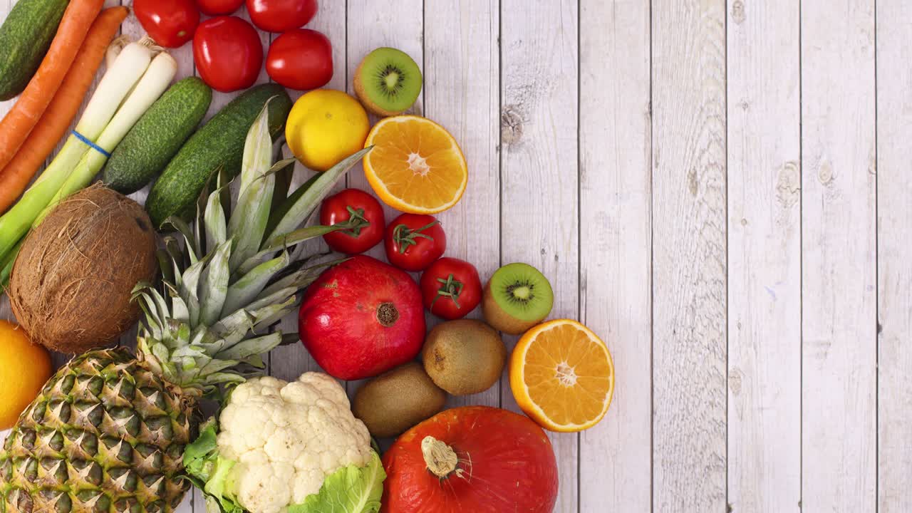 Organic vegetables and fruits appear on left side of light wooden  theme. Stop motion