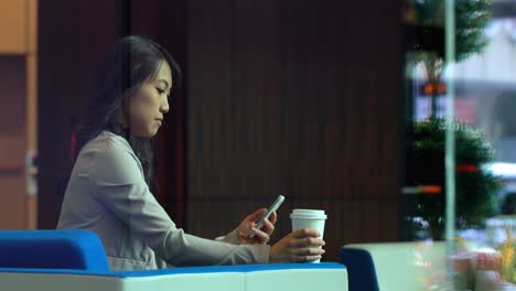mujer de negocios usando teléfono móvil en la oficina 4k