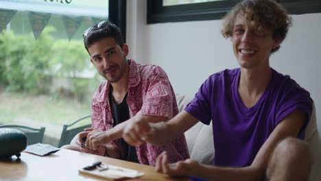 two friends interacting at a table indoors