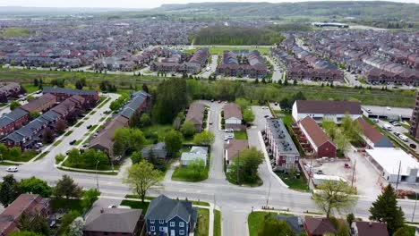 Drone-tilting-up-over-Milton-neighborhood-on-an-overcast-summer-day