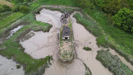 vista aérea de un barco más ligero atascado en el barro en el parque de campo wat tyler, basildon nublado, reino unido - inclinación, disparo de drones