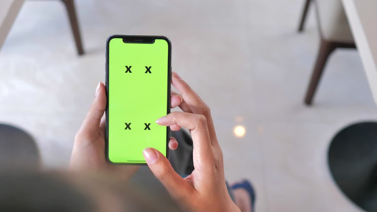 초록색 화면 을 가진 스마트 폰 을 사용하는 여자