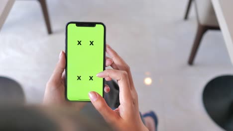 mujer usando un teléfono inteligente con pantalla verde