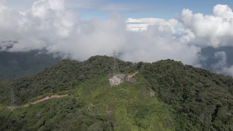 tropical mountain flyover of high voltage transmission lines, malaysia