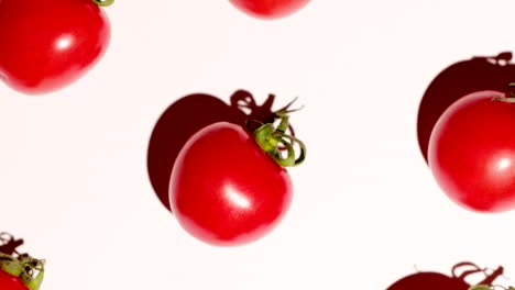 tomates de cereza girando sobre un fondo blanco, un ligero zoom hacia afuera