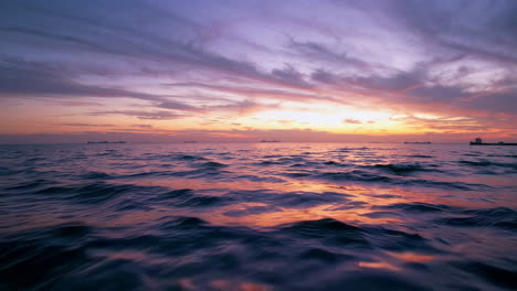 sunset over the ocean with ships