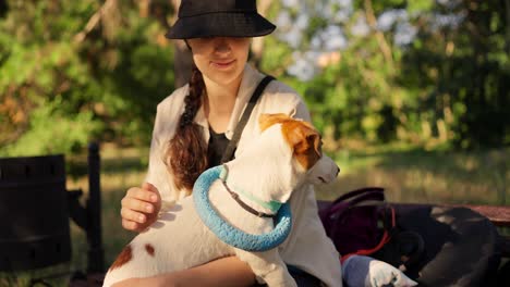 woman and her jack russel terrier dog sitting in the park