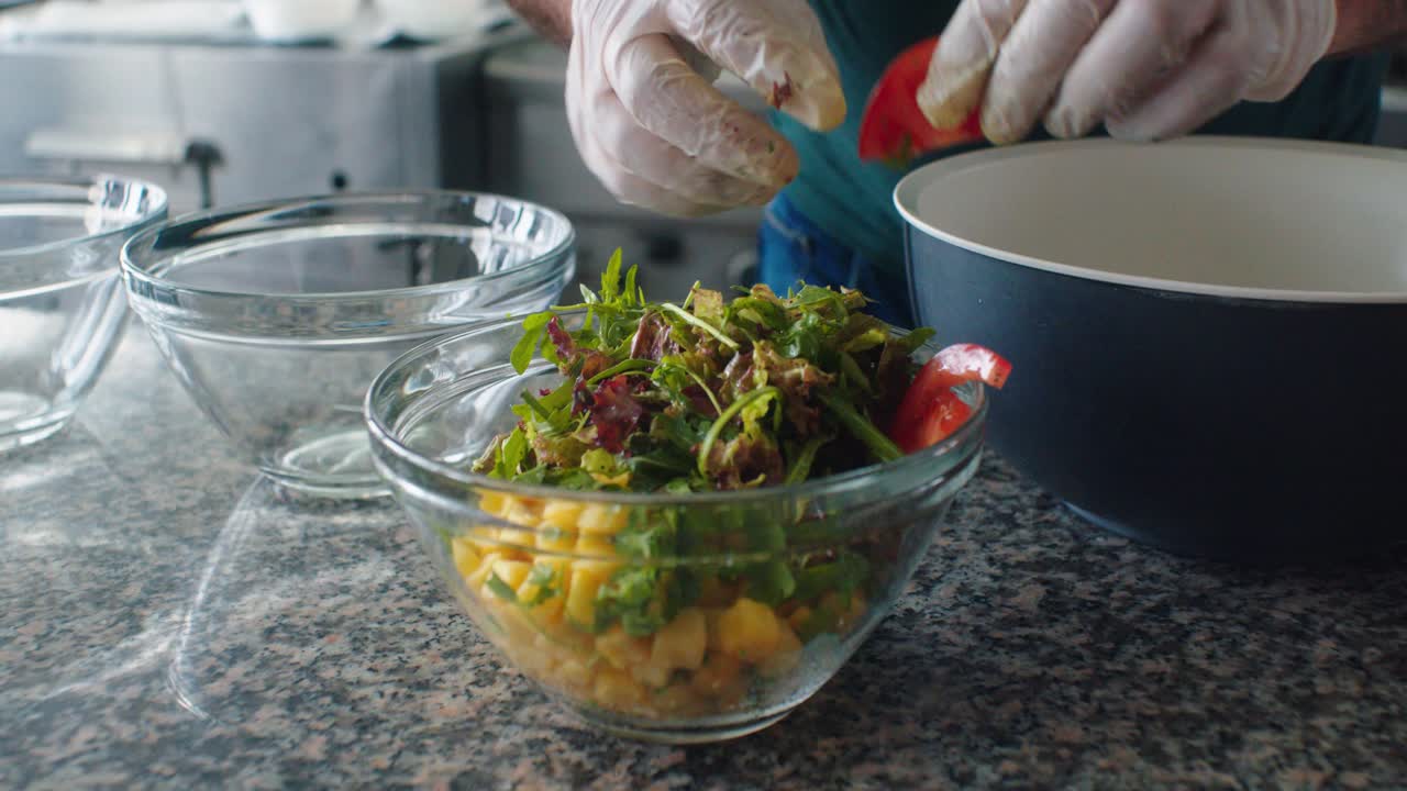 el cocinero poniendo los tomates en la ensalada
