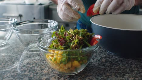 the cook putting the tomatos into the salad